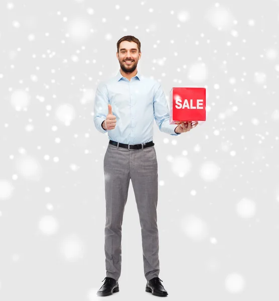 Hombre sonriente con bolsa de compras roja — Foto de Stock