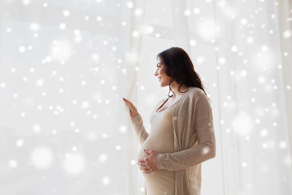 Mujer embarazada feliz mirando a la ventana — Foto de Stock