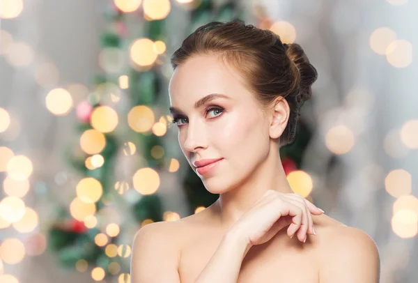 Beautiful young woman face over christmas lights — Stock fotografie