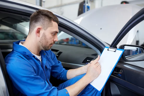 Auto mekaniker man med Urklipp på bilverkstad — Stockfoto