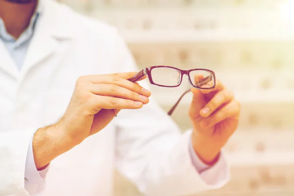 Primer plano del óptico con gafas en la tienda de óptica —  Fotos de Stock