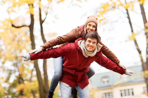 Счастливая молодая пара веселится в осеннем парке — стоковое фото