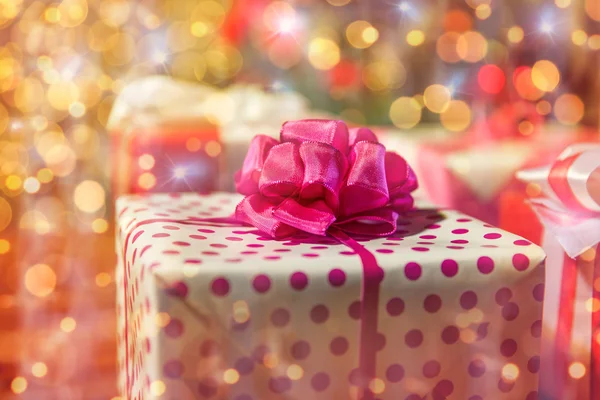 Primer plano de las cajas de regalo sobre las luces del árbol de Navidad —  Fotos de Stock