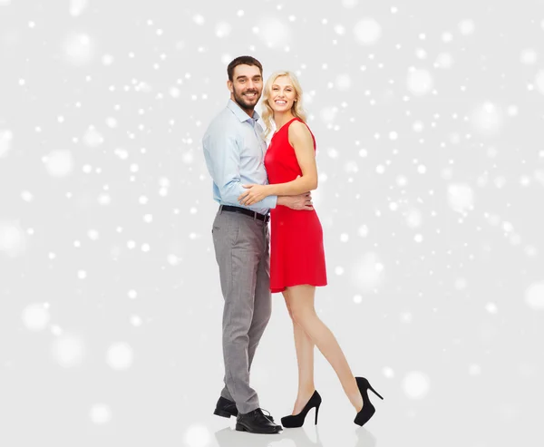 Happy couple hugging over snow background — ストック写真