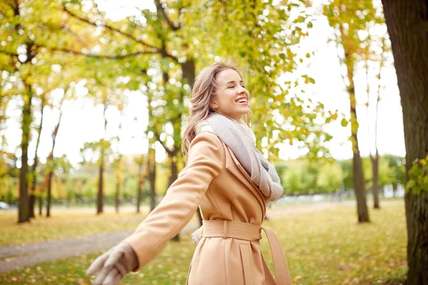 สาวสวยมีความสุข เดินในสวนฤดูใบไม้ร่วง — ภาพถ่ายสต็อก