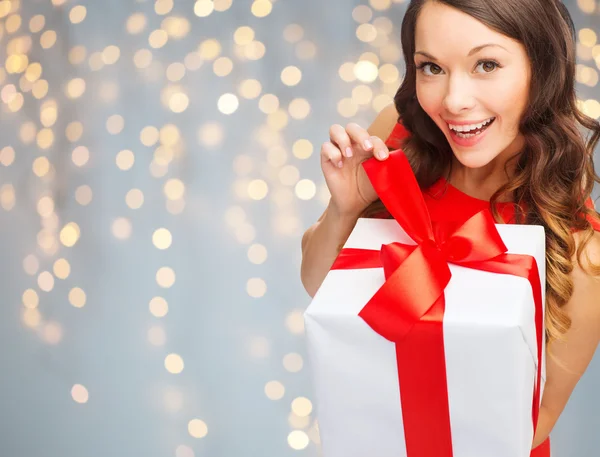 Mujer sonriente en vestido rojo con caja de regalo —  Fotos de Stock