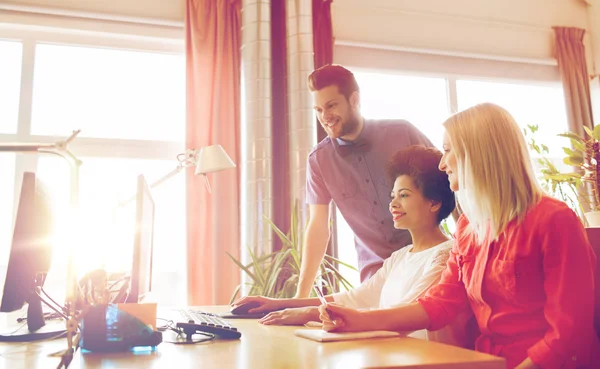 Equipe criativa feliz com computador no escritório — Fotografia de Stock