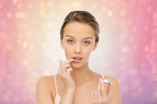 Young woman applying lip balm to her lips — Stock Photo, Image