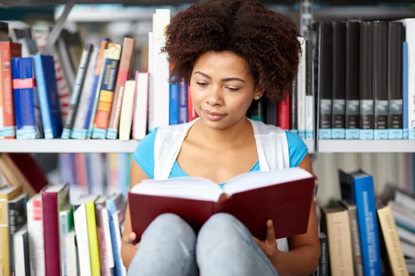 Africano studente ragazza lettura libro a biblioteca — Foto Stock