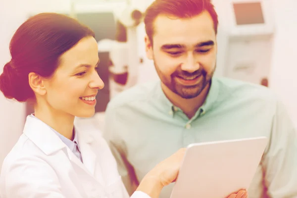 Opticien met tablet pc en patiënt bij kliniek van het oog — Stockfoto