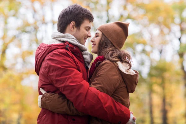 Feliz pareja joven abrazándose en el parque de otoño —  Fotos de Stock