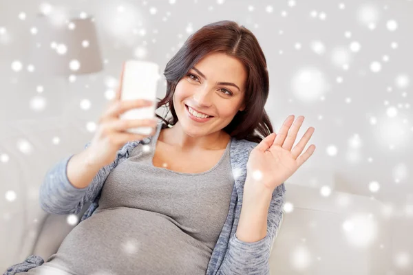 Mujer embarazada feliz con teléfono inteligente en casa — Foto de Stock