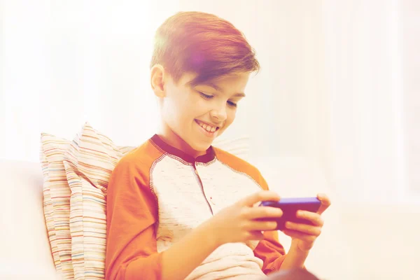 Fiú okostelefon sms-ezés vagy játék otthon — Stock Fotó