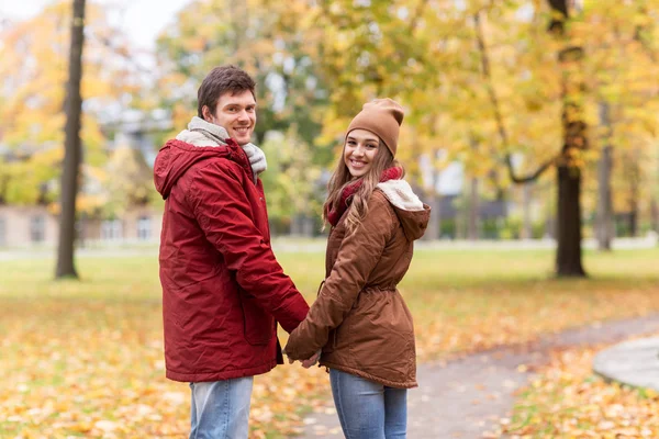 Felice giovane coppia a piedi nel parco autunnale — Foto Stock