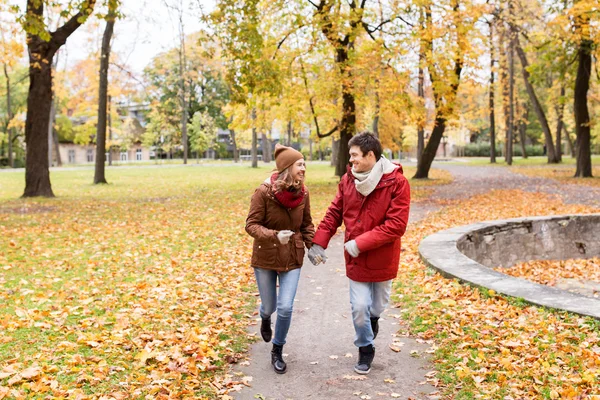 Heureux jeune couple courir dans le parc d'automne — Photo