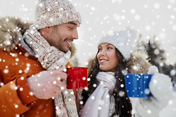 Feliz pareja con tazas de té sobre el paisaje de invierno —  Fotos de Stock