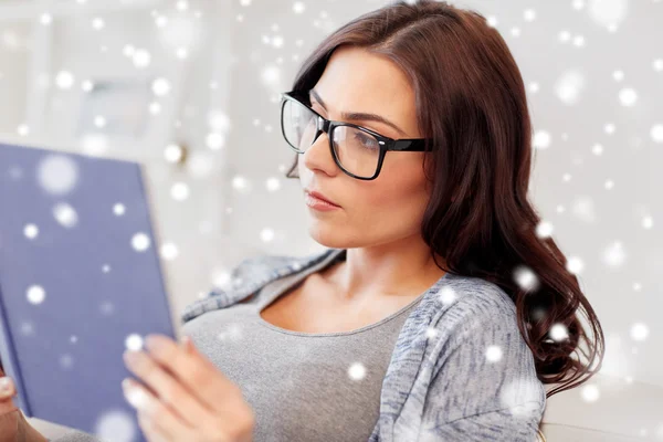 Jonge vrouw in glazen lezen boek thuis — Stockfoto