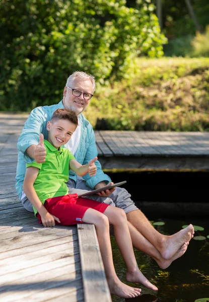 Abuelo y niño con la tableta de la PC en la litera del río —  Fotos de Stock