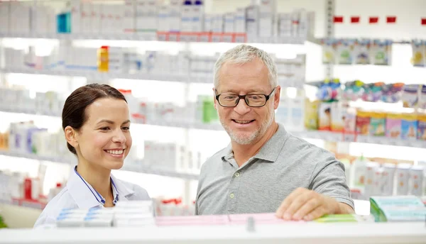 Farmacista felice parlando con l'uomo anziano in farmacia — Foto Stock