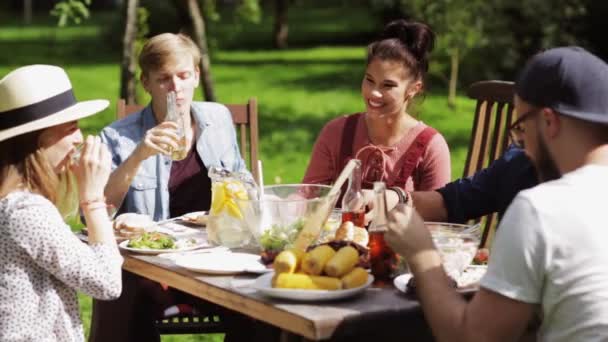 Glückliche Freunde beim Abendessen bei sommerlicher Gartenparty — Stockvideo