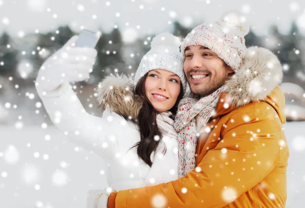 Casal feliz tomando selfie por smartphone no inverno — Fotografia de Stock