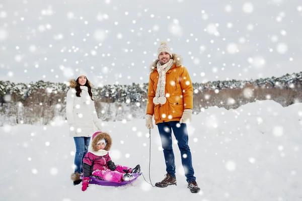 Щаслива сім'я з санчатами, що ходять взимку на відкритому повітрі — стокове фото