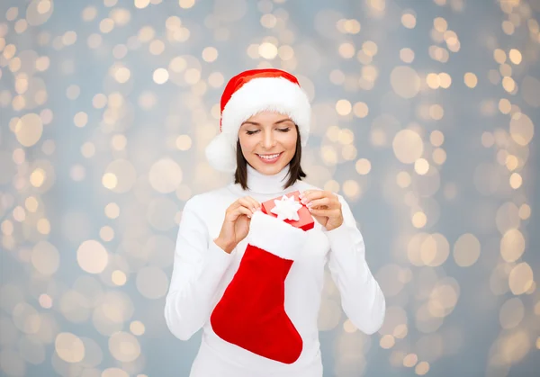 Donna in cappello da Babbo Natale con confezione regalo e calza — Foto Stock