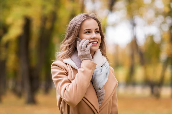 Kvinna ringer på smartphone i höst park — Stockfoto