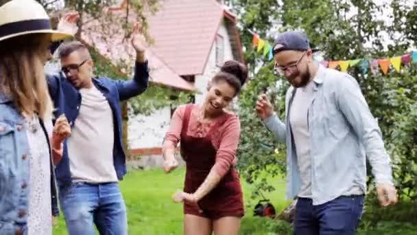 Happy vrienden dansen op zomer party in de tuin — Stockvideo