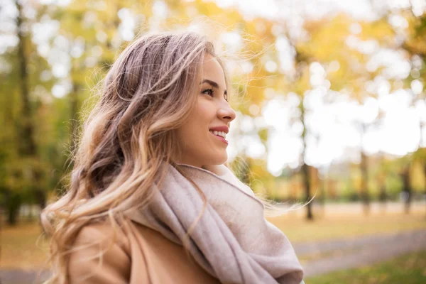 秋の公園で笑みを浮かべて美しい幸せな若い女 — ストック写真