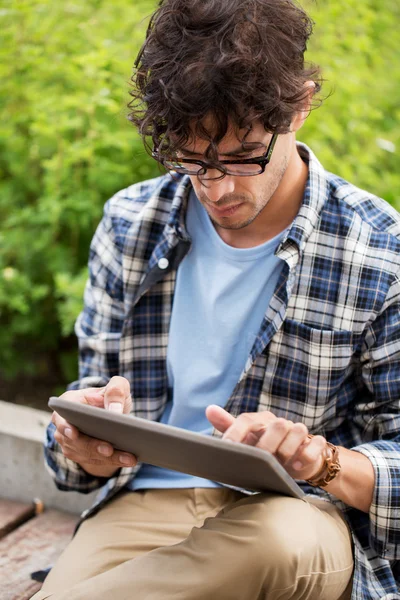 Człowiek w okularach z komputerem typu tablet pc na zewnątrz — Zdjęcie stockowe