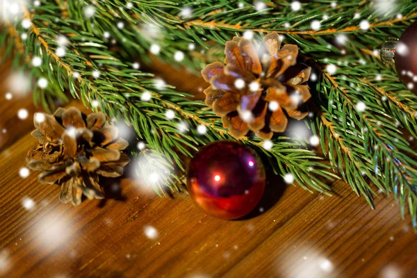 Fir branch with christmas ball and pinecones — Stock Photo, Image