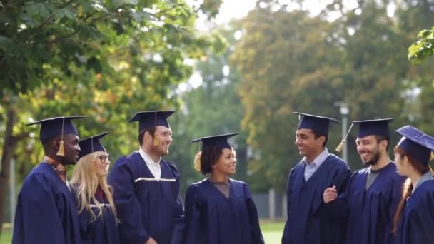 Estudantes felizes jogando placas de argamassa para cima — Vídeo de Stock