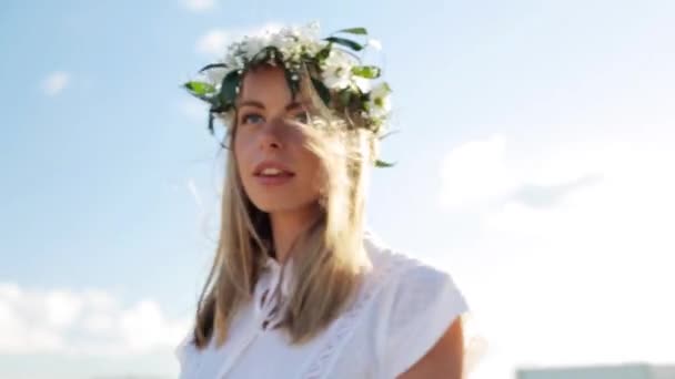 Mosolygó fiatal nő a szabadban virágok koszorút — Stock videók