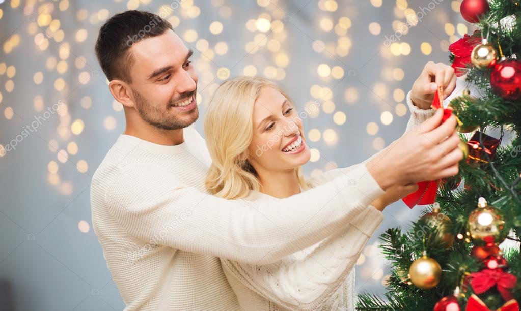 family x mas winter holidays and people concept happy couple decorating christmas tree over lights background photo by syda_productions - People Decorating A Christmas Tree family x mas winter holidays and people concept happy couple decorating christmas tree over lights background photo by syda_productions - People Decorating A Christmas Tree