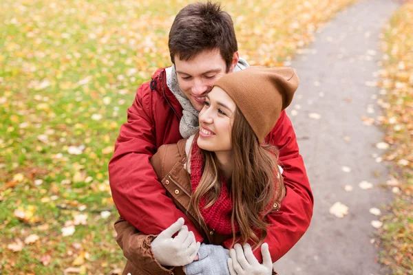 Gelukkige jonge paar knuffelen in herfst park — Stockfoto