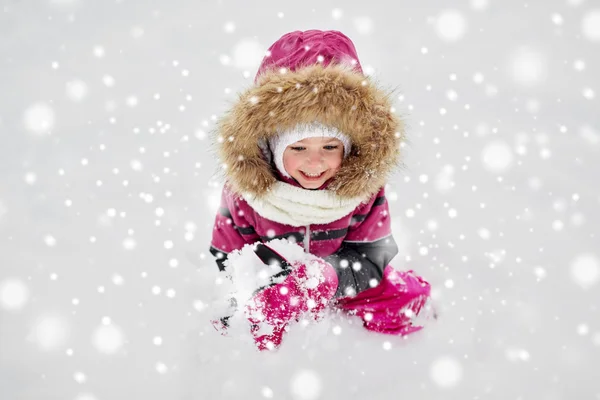 F šťastné malé dítě nebo holka se sněhem v zimě — Stock fotografie