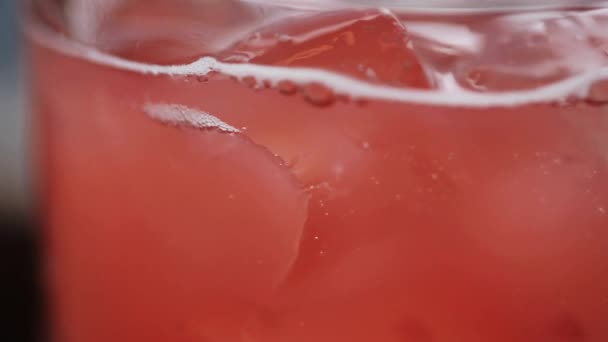 Rosa Limonade im Glas mit Eiswürfeln — Stockvideo