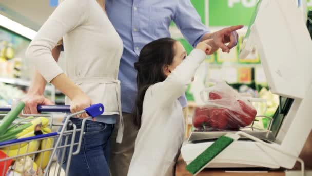 Семья взвешивает паприку на весах в продуктовом магазине — стоковое видео