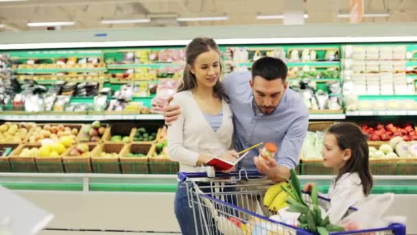 Família com alimentos no carrinho de compras na mercearia — Vídeo de Stock