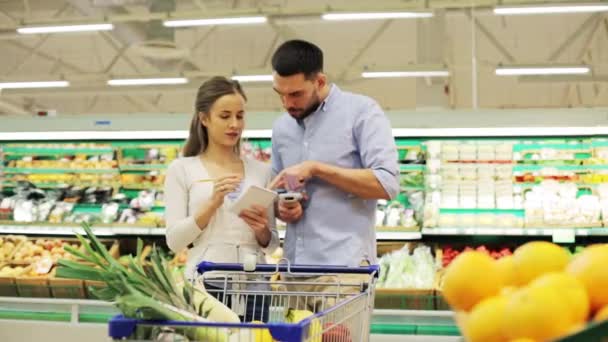 Casal com alimentos no carrinho de compras na mercearia — Vídeo de Stock