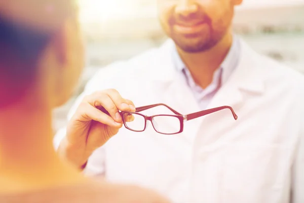 Close up of optician with glasses at optics store — Stock Photo, Image