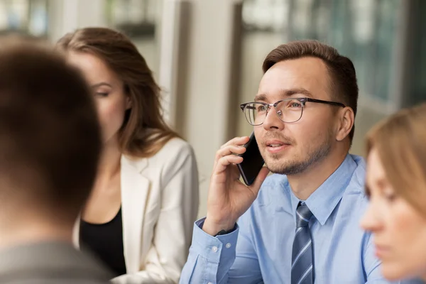 Uomo d'affari che chiama su smartphone in ufficio — Foto Stock