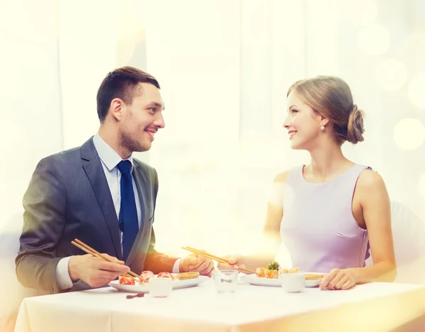 Sorrindo casal comer sushi no restaurante — Fotografia de Stock