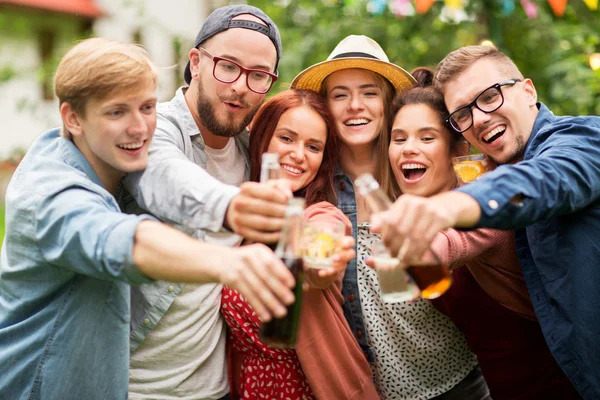 Happy vrienden rammelende glazen op zomertuin — Stockfoto