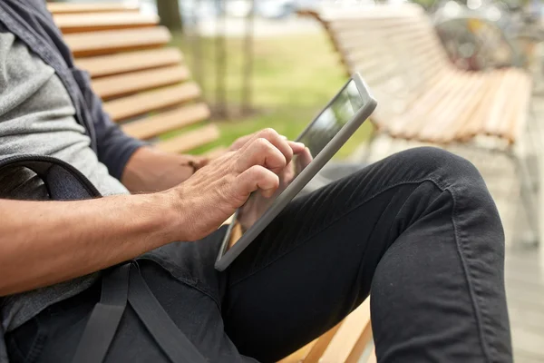 Närbild på mannen med TabletPC sitter på bänk — Stockfoto