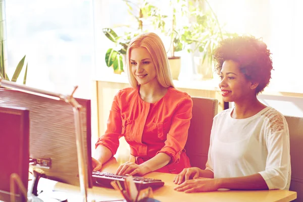 Mujeres felices o estudiantes con computadora en la oficina — Foto de Stock