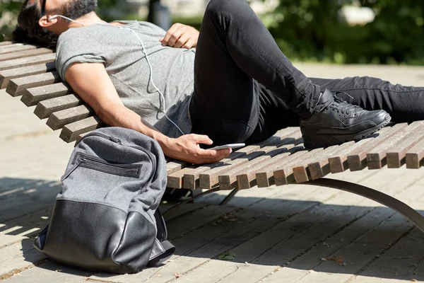 Man with smartphone and earphones listening music — Stock Photo, Image