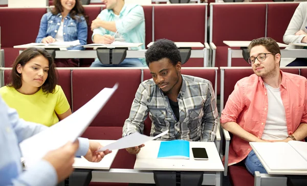 Docent geeft examens aan studenten op college — Stockfoto