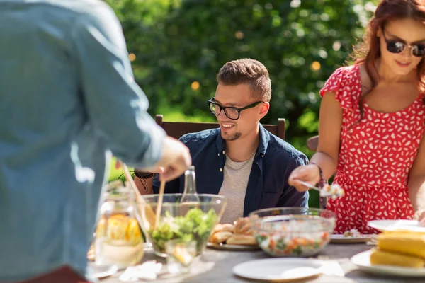 Счастливые друзья, ужинающие на вечеринке в летнем саду — стоковое фото